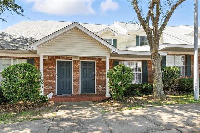 2738 W Tharpe St Unit 2302, Tallahassee, FL 32303 - view of front of property with brick siding, a porch, and roof with shingles