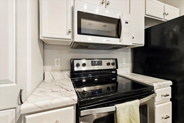 2738 W Tharpe St Unit 2302, Tallahassee, FL 32303 - kitchen featuring stainless steel range with electric stovetop, white microwave, and white cabinetry