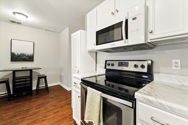 2738 W Tharpe St Unit 2302, Tallahassee, FL 32303 - kitchen featuring stainless steel range with electric stovetop, white microwave, dark wood-style flooring, and white cabinets