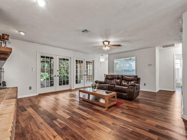 living room featuring a healthy amount of sunlight, dark wood-type flooring, and french doors