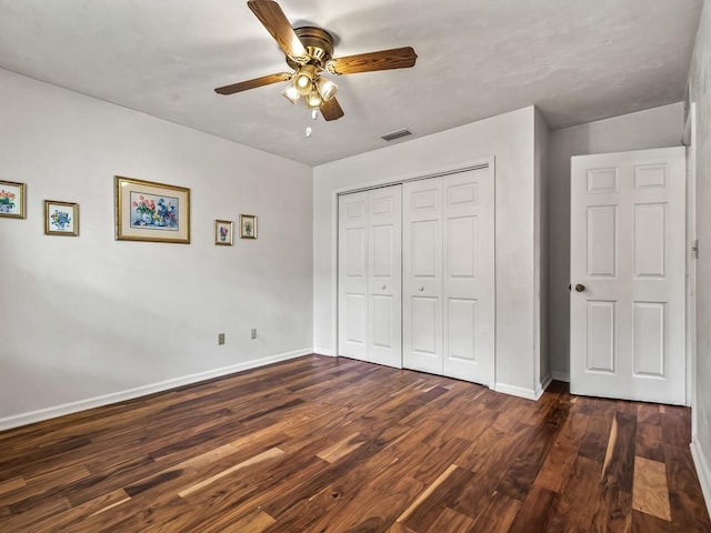 unfurnished bedroom with ceiling fan, dark hardwood / wood-style flooring, and a closet