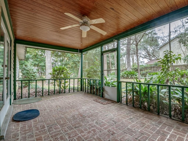 unfurnished sunroom with wood ceiling and ceiling fan