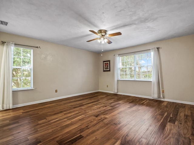 spare room with dark hardwood / wood-style flooring and ceiling fan