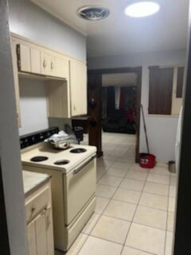 212 Susan St, Perry, FL 32348 - kitchen featuring white range with electric stovetop, light tile patterned floors, and light countertops