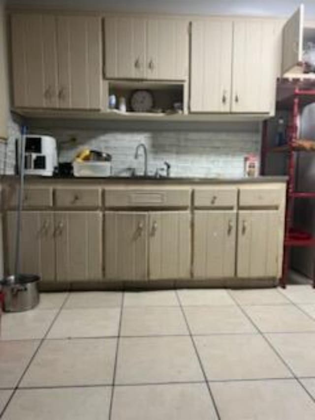 212 Susan St, Perry, FL 32348 - kitchen featuring a sink, open shelves, light tile patterned floors, and tasteful backsplash