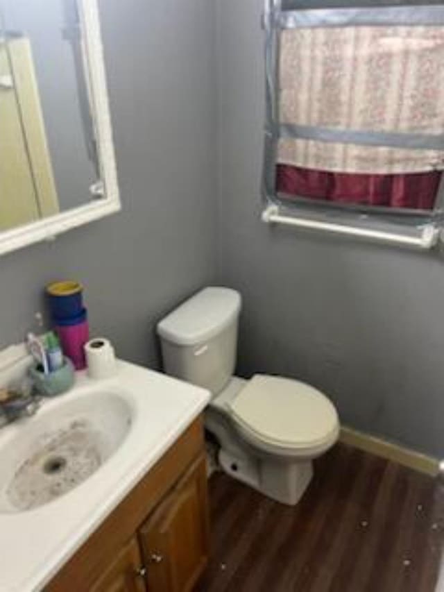 212 Susan St, Perry, FL 32348 - half bath with wood finished floors, vanity, toilet, and baseboards
