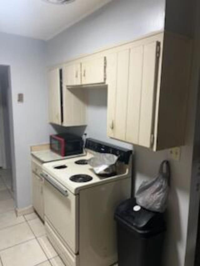 212 Susan St, Perry, FL 32348 - kitchen featuring white electric stove, light tile patterned floors, and light countertops