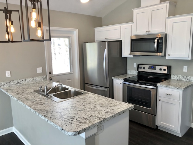 kitchen with kitchen peninsula, hanging light fixtures, white cabinets, and stainless steel appliances