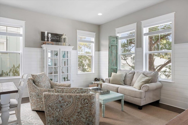 living room with hardwood / wood-style flooring and wood walls