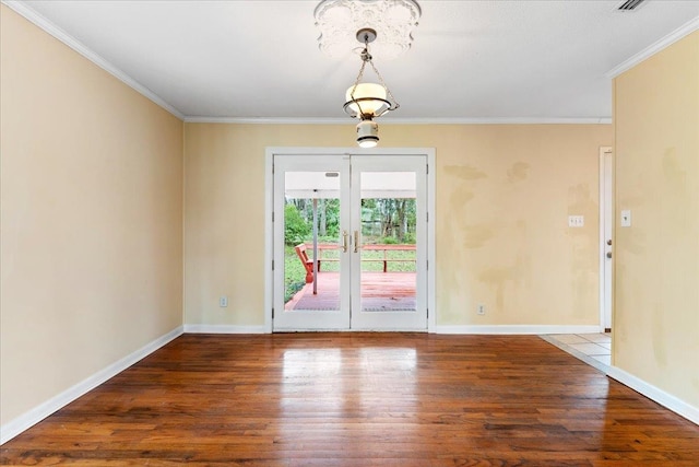 empty room featuring baseboards, wood finished floors, and ornamental molding