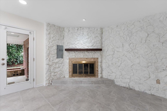 unfurnished living room with a glass covered fireplace, tile patterned floors, and recessed lighting