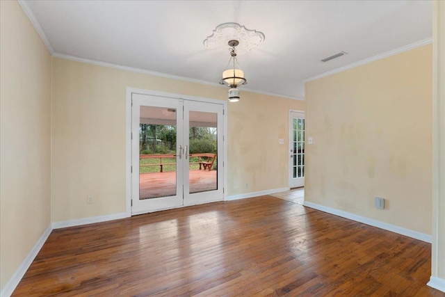 unfurnished room featuring wood finished floors, baseboards, visible vents, ornamental molding, and french doors