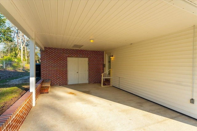 view of patio / terrace with an attached carport and fence