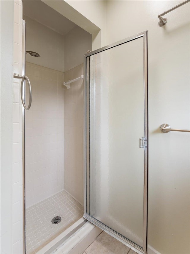 full bath featuring tile patterned flooring and a shower stall