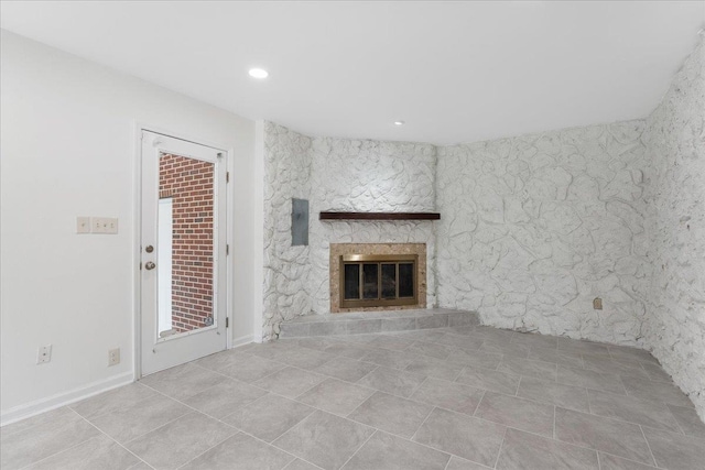 unfurnished living room featuring recessed lighting and a stone fireplace