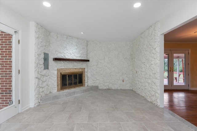 unfurnished living room with recessed lighting, french doors, and a glass covered fireplace