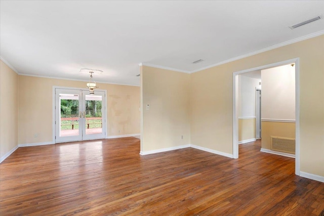 empty room featuring visible vents, crown molding, and wood finished floors