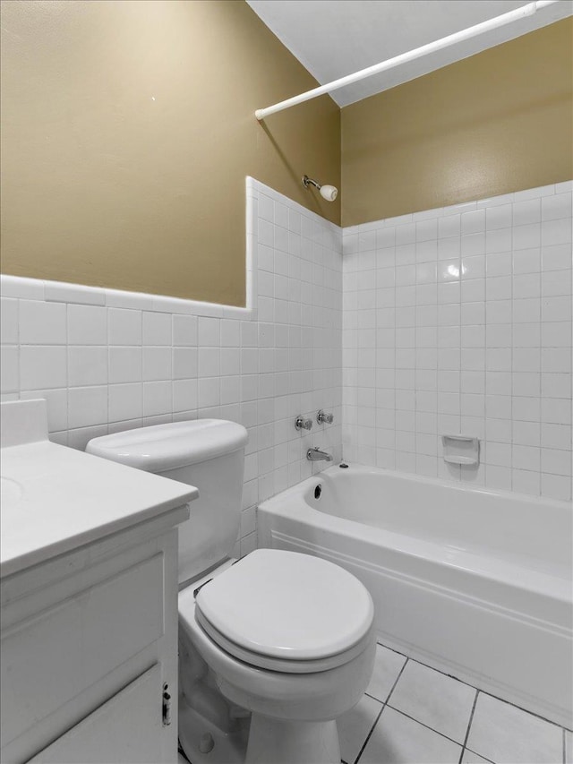 full bathroom featuring vanity, tile patterned flooring, shower / tub combination, toilet, and tile walls