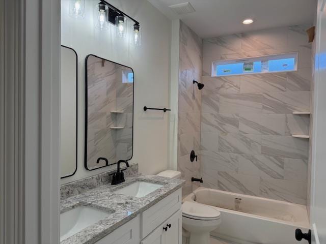 full bathroom with vanity, tiled shower / bath combo, and toilet