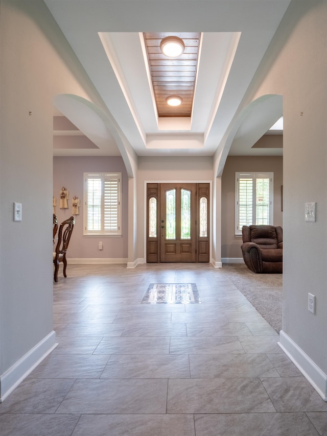 foyer entrance with a raised ceiling