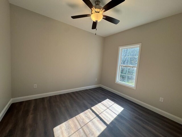 spare room featuring ceiling fan and dark wood-type flooring