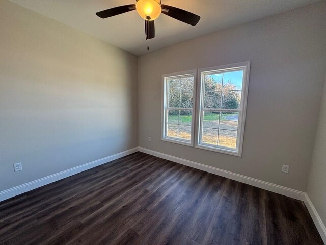 spare room featuring ceiling fan and dark wood-type flooring