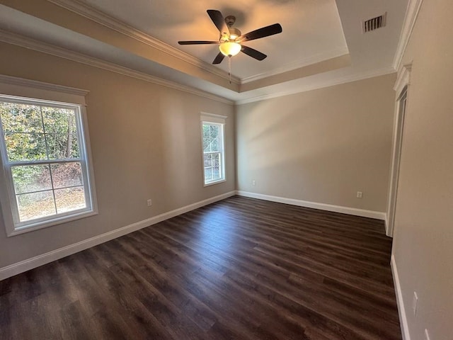 spare room featuring a raised ceiling, ceiling fan, dark wood-type flooring, and ornamental molding