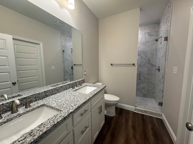 bathroom featuring hardwood / wood-style flooring, vanity, toilet, and a shower with shower door