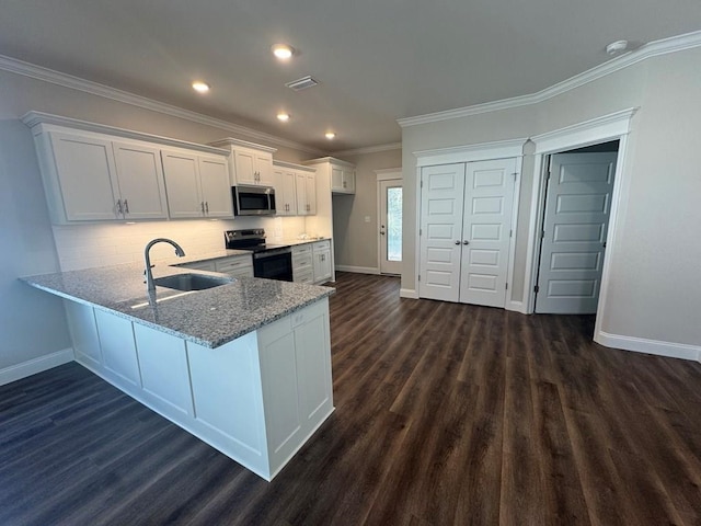 kitchen featuring backsplash, sink, dark hardwood / wood-style flooring, white cabinetry, and stainless steel appliances