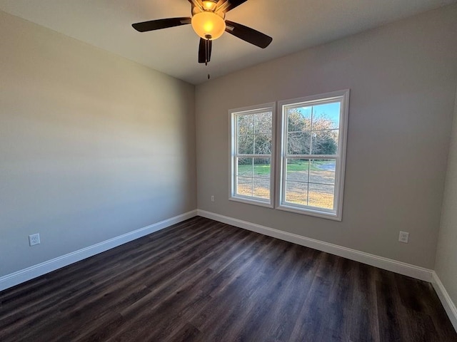 empty room with ceiling fan and dark hardwood / wood-style flooring