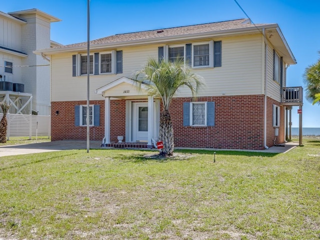 1455 Alligator Dr, Alligator Point, FL 32346 - view of front of property with brick siding, a front yard, driveway, and a balcony