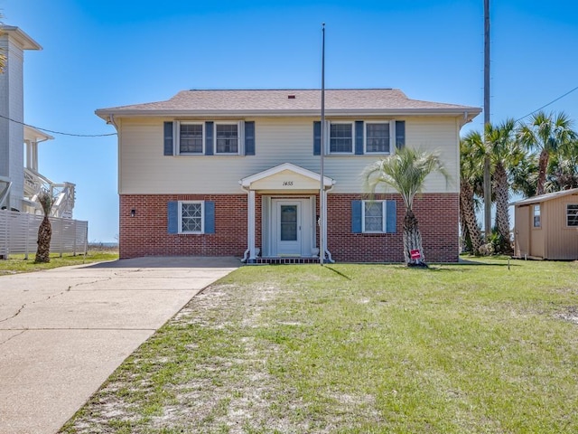 1455 Alligator Dr, Alligator Point, FL 32346 - view of front facade featuring brick siding, a front yard, and concrete driveway