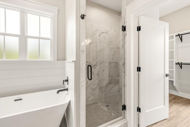 bathroom with hardwood / wood-style flooring and independent shower and bath