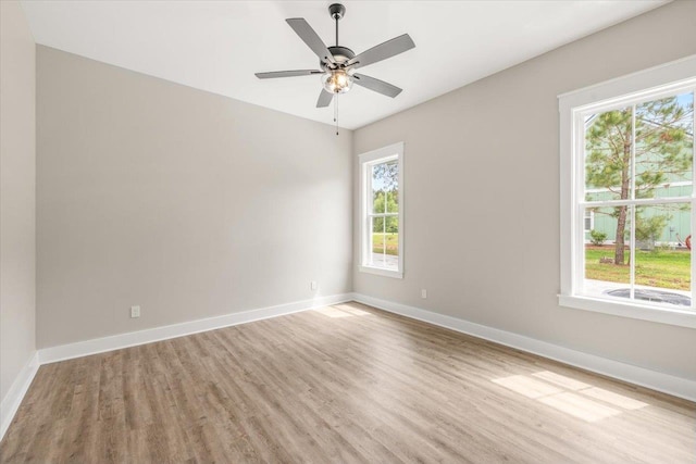 spare room with plenty of natural light, ceiling fan, and light wood-type flooring