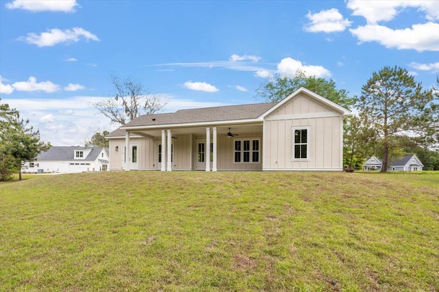 back of property with ceiling fan and a lawn