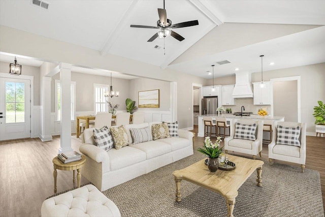 5410 Peace Dove Trl, Tallahassee, FL 32311 - living room featuring light wood-style floors, a chandelier, a wainscoted wall, healthy amount of natural light, and a decorative wall