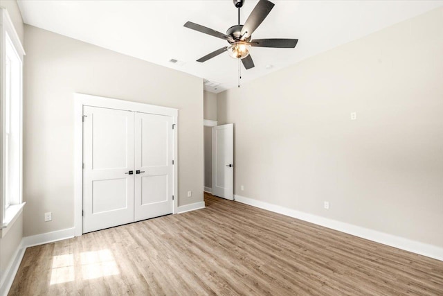 unfurnished bedroom with ceiling fan, a closet, and light hardwood / wood-style flooring