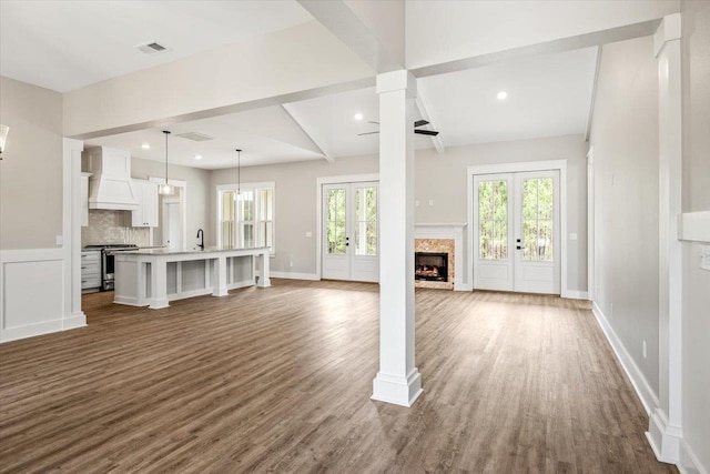 unfurnished living room with ceiling fan, french doors, sink, dark wood-type flooring, and lofted ceiling