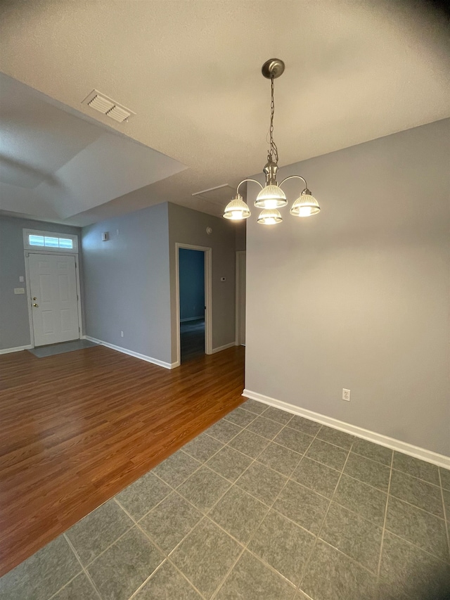 empty room with dark hardwood / wood-style flooring and a textured ceiling