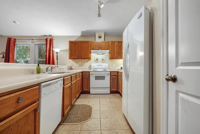 5529 Green Meadows Ct, Tallahassee, FL 32303 - kitchen featuring white appliances, brown cabinets, light tile patterned floors, under cabinet range hood, and light countertops