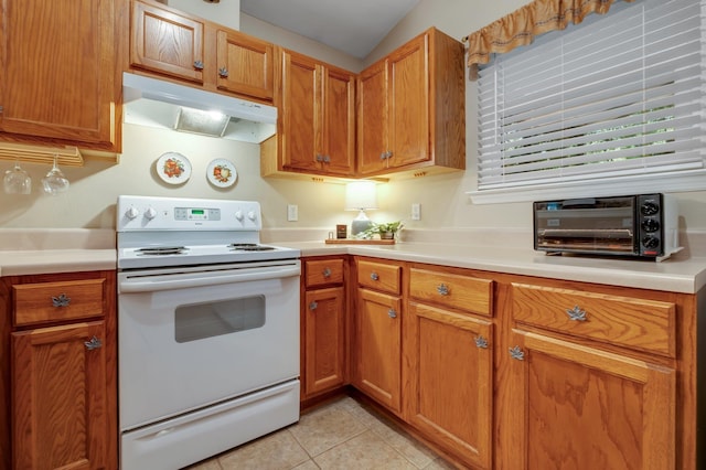 5529 Green Meadows Ct, Tallahassee, FL 32303 - kitchen with white range with electric cooktop, under cabinet range hood, light countertops, light tile patterned flooring, and brown cabinetry