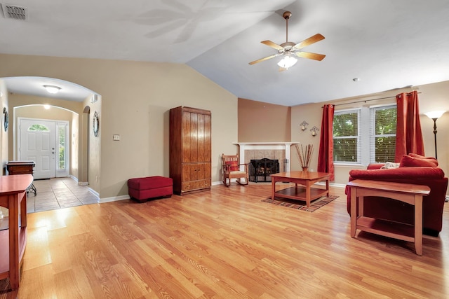 5529 Green Meadows Ct, Tallahassee, FL 32303 - living room featuring ceiling fan, arched walkways, light wood-type flooring, vaulted ceiling, and a fireplace