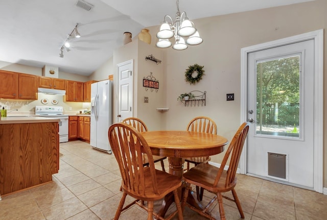 5529 Green Meadows Ct, Tallahassee, FL 32303 - dining space with vaulted ceiling, track lighting, light tile patterned flooring, a chandelier, and healthy amount of natural light