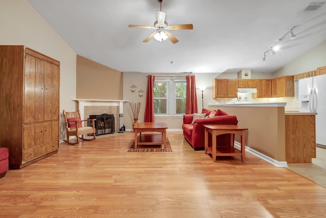 5529 Green Meadows Ct, Tallahassee, FL 32303 - living room featuring lofted ceiling, light wood finished floors, a ceiling fan, a tile fireplace, and rail lighting