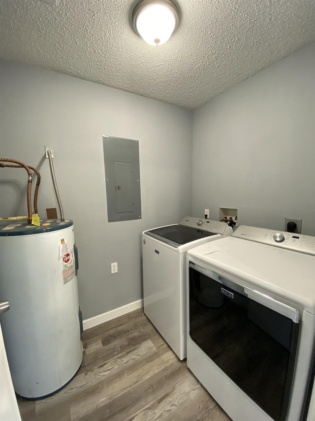 clothes washing area with water heater, hardwood / wood-style floors, electric panel, independent washer and dryer, and a textured ceiling