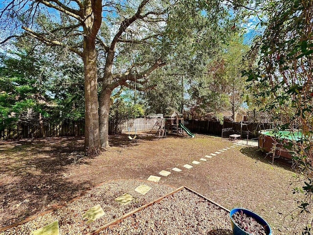 view of yard featuring a fenced backyard and a playground