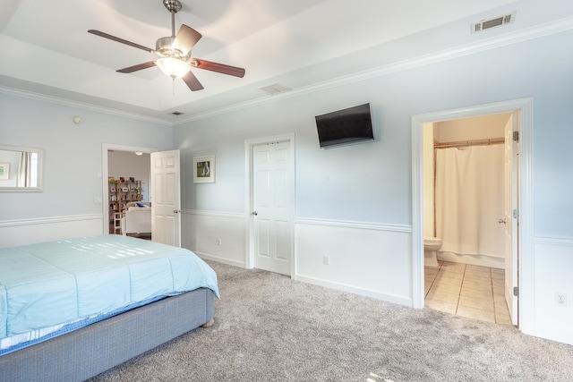 bedroom with light carpet, visible vents, a raised ceiling, and crown molding