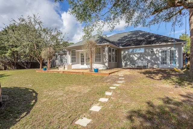 back of property featuring a yard and fence