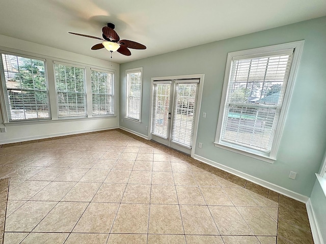 unfurnished sunroom featuring a ceiling fan and french doors