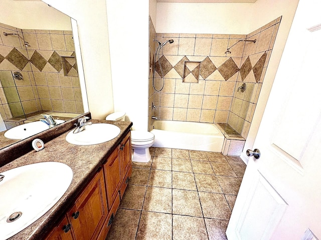 bathroom with double vanity, toilet, a sink, and tile patterned floors